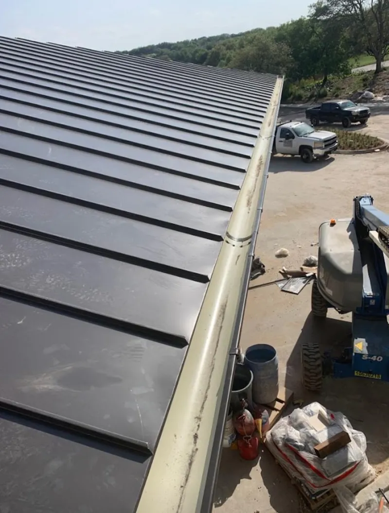 Standing seam panel and gutter detail on a metal roofing jobsite in Carencro